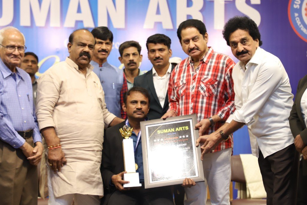Dr. Venu Babu and Anu's Dental team receiving a framed certificate at the Suman Arts awards ceremony